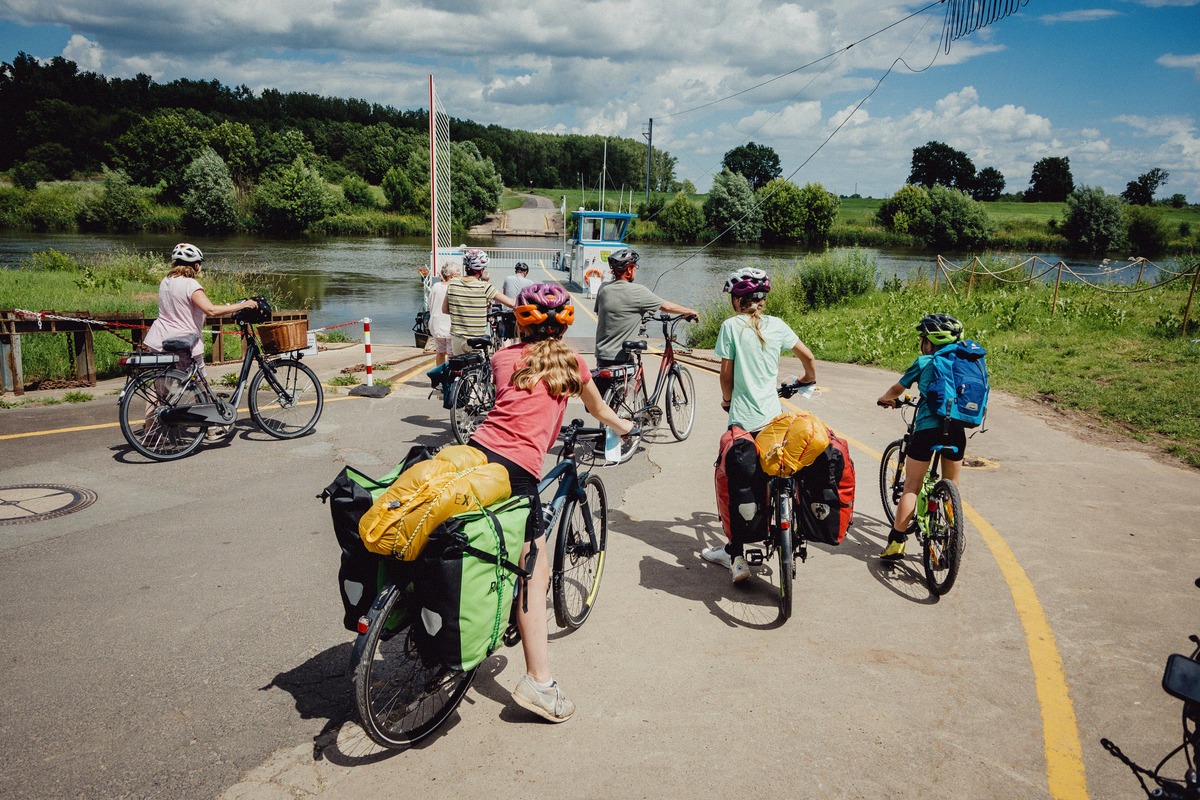 Family with loaded bicycles riding onto a ferry